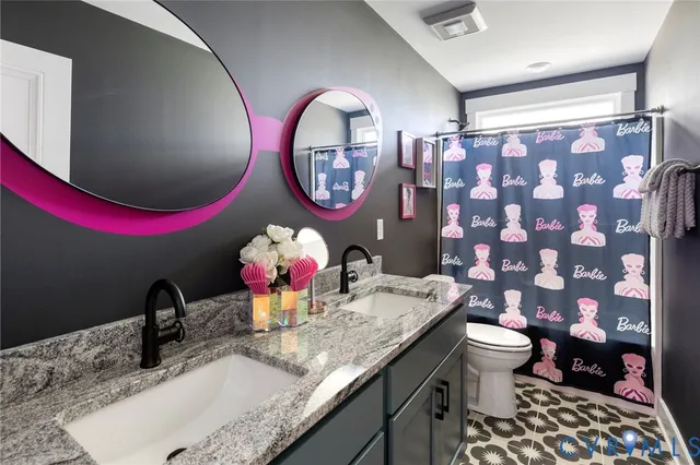a bathroom with a granite countertop toilet a sink and a mirror