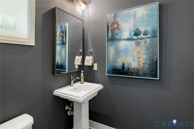 a bathroom with a sink mirror and toilet