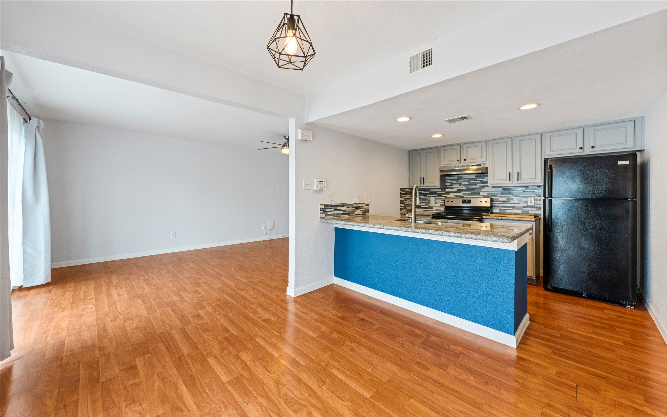 2124 Burton Drive, Unit 159 Austin, TX 78741 - Photo 6 of 23 A well-lit kitchen with granite counters and wood flooring flows seamlessly into a spacious living area.