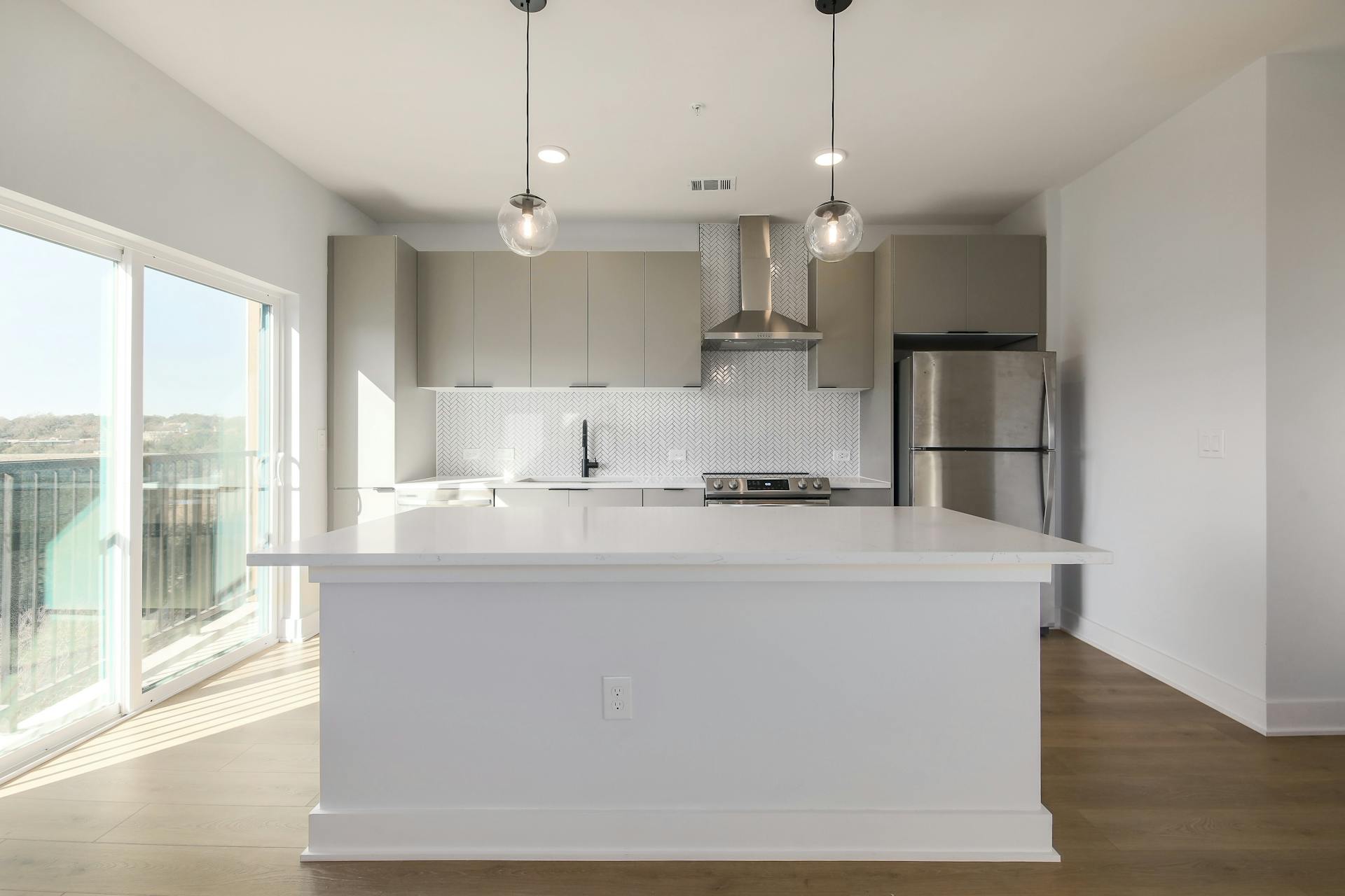 2500 Longview Street, Unit 501 Austin, TX 78705 - Photo 1 of 23 Kitchen featuring stainless steel appliances, gray cabinetry, decorative backsplash, dark wood-style flooring, and hanging light fixtures