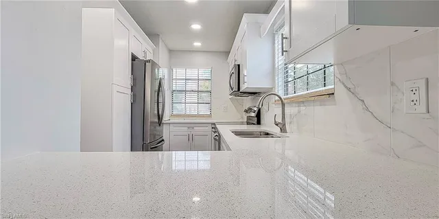 a kitchen with granite countertop a sink and a stove top oven
