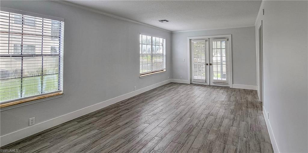 5367 Treetops Drive, Unit M101 Naples, FL 34113 - Photo 2 of 6 a view of an empty room with wooden floor and a window
