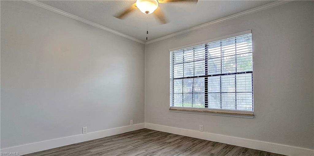 5367 Treetops Drive, Unit M101 Naples, FL 34113 - Photo 3 of 6 wooden floor in an empty room with a window
