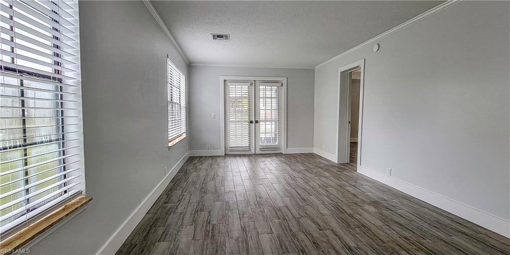 5367 Treetops Drive, Unit M101 Naples, FL 34113 - Photo 4 of 6 a view of an empty room with wooden floor and a window