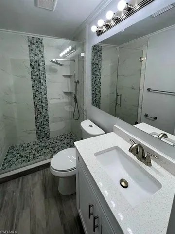 a bathroom with a sink a toilet and shower