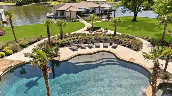 a picture of a lake with a garden and swimming pool