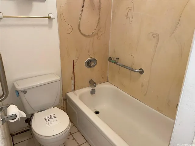 a white toilet sitting next to a bath tub