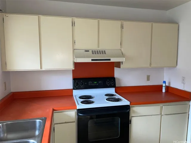 a kitchen with a stove a sink and a microwave