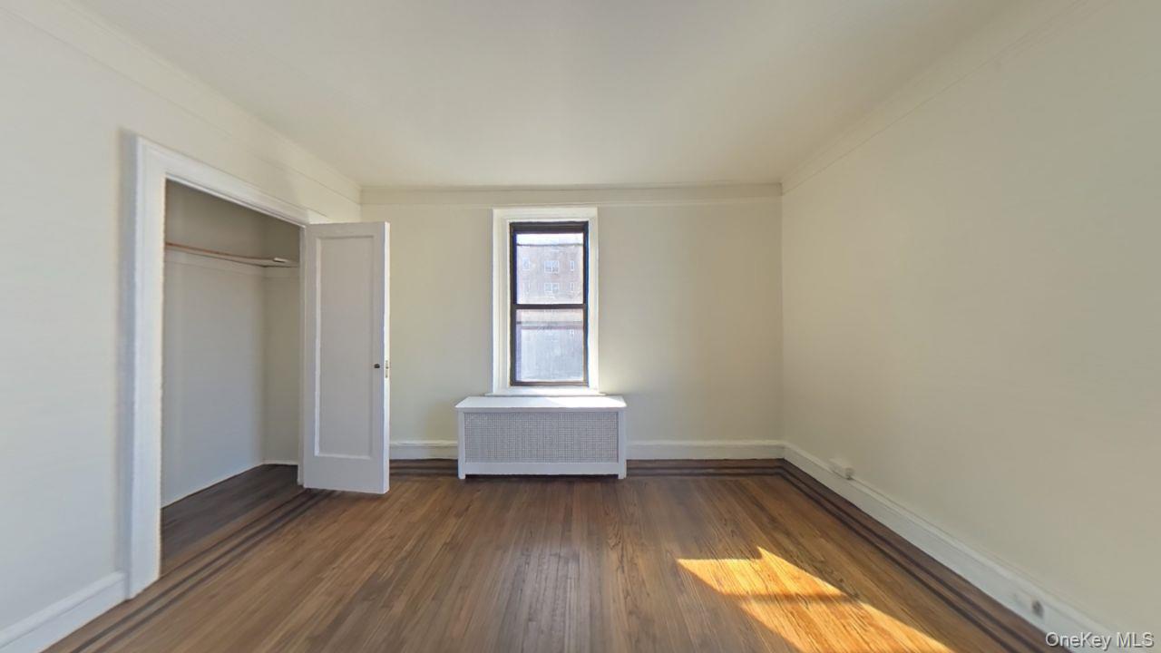 100 Pelham Road, Unit 2B New Rochelle, NY 10805 - Photo 4 of 13 an empty room with wooden floor and windows