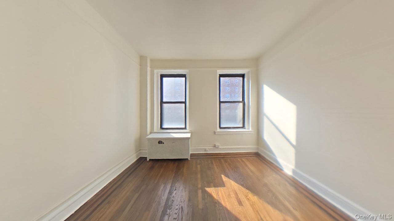 100 Pelham Road, Unit 2B New Rochelle, NY 10805 - Photo 6 of 13 an empty room with wooden floor and windows