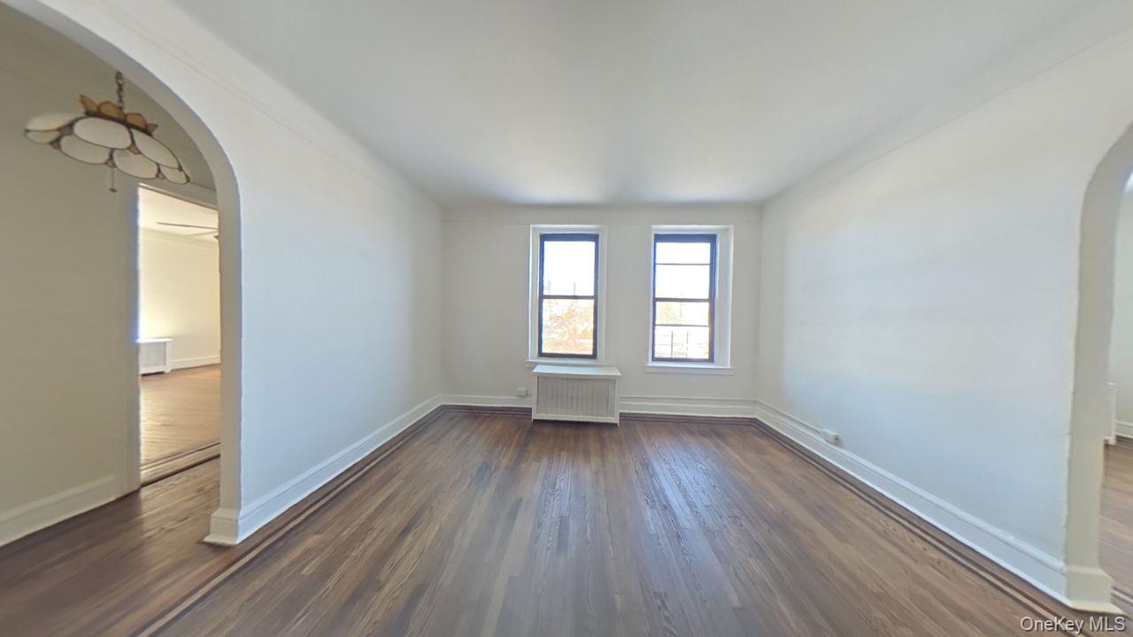 100 Pelham Road, Unit 2B New Rochelle, NY 10805 - Photo 8 of 13 an empty room with wooden floor and windows