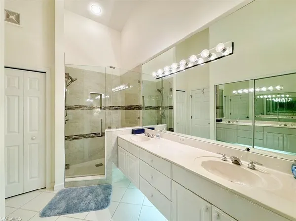 a spacious bathroom with a shower sink and mirror