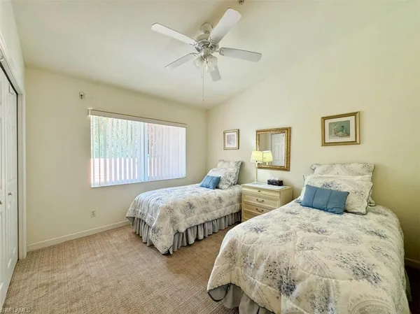 a bedroom with two beds and ceiling fan