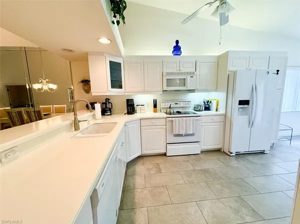 a kitchen with a sink a stove a refrigerator and cabinets