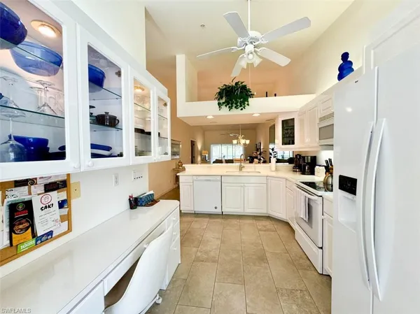a kitchen with stainless steel appliances cabinets and a ceiling fan