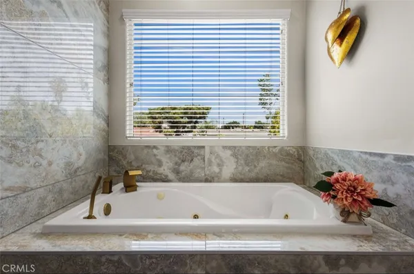 a bathroom with a tub a sink and a window