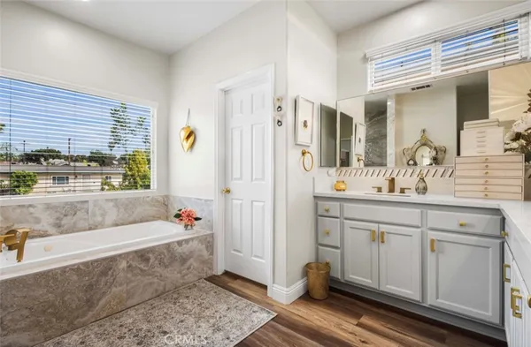 a bathroom with a tub a sink and a large mirror