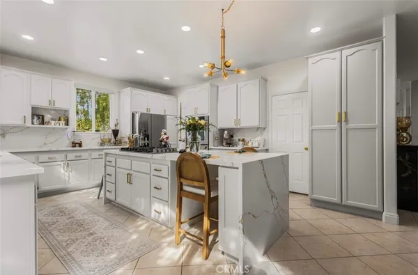 a kitchen with kitchen island granite countertop appliances cabinets and a sink
