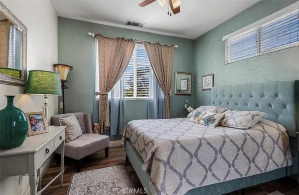 a bedroom with a bed wooden floor and window
