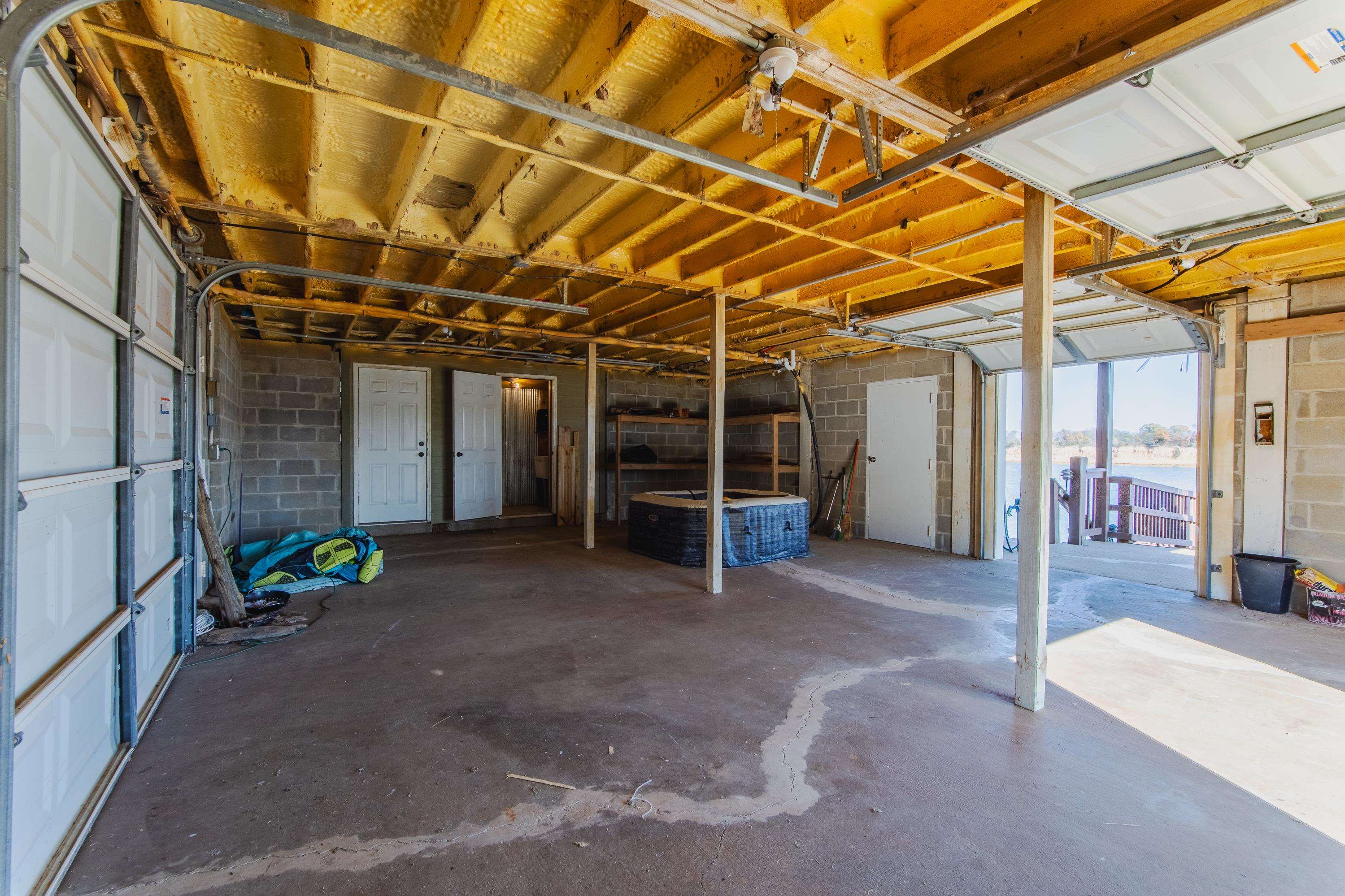 1111 Leaning Trees Lane Adamsville, TN 38310 - Photo 29 of 36 Expansive garage space with concrete flooring and exposed wood ceiling joists