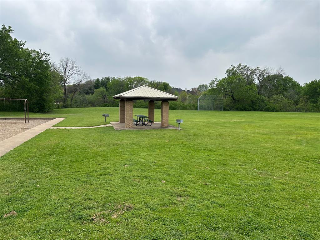 3101 Buckthorn Street Forney, TX 75126 - Photo 37 of 40 Expansive green space featuring a covered pavilion with a picnic table, a built-in barbecue grill, and a concrete pathway