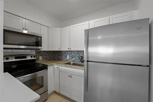 a kitchen with a refrigerator and a stove top oven
