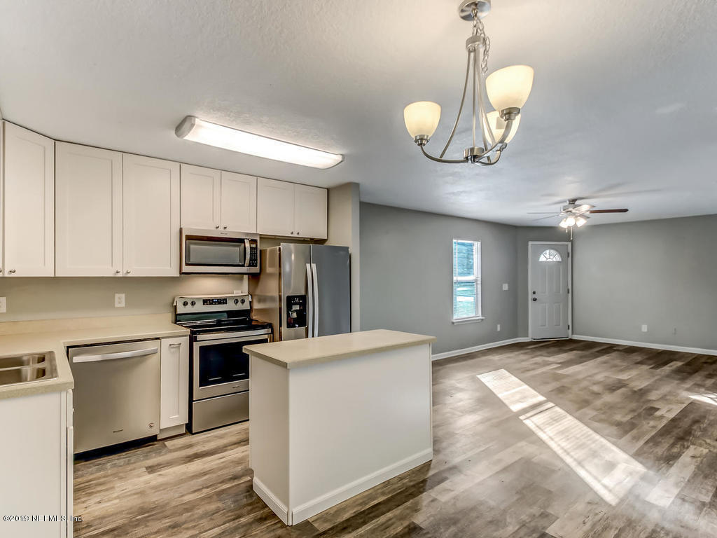 2165 Tuskegee Road Jacksonville, FL 32209 - Photo 13 of 32 a kitchen with kitchen island granite countertop stainless steel appliances a stove refrigerator and microwave