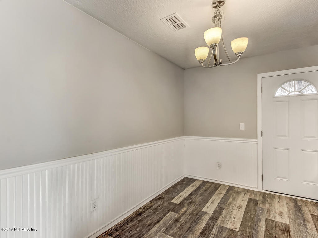 2165 Tuskegee Road Jacksonville, FL 32209 - Photo 14 of 32 a view of a room with wooden floor and chandelier