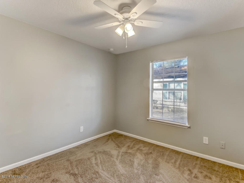 2165 Tuskegee Road Jacksonville, FL 32209 - Photo 22 of 32 an empty room with a chandelier fan and windows