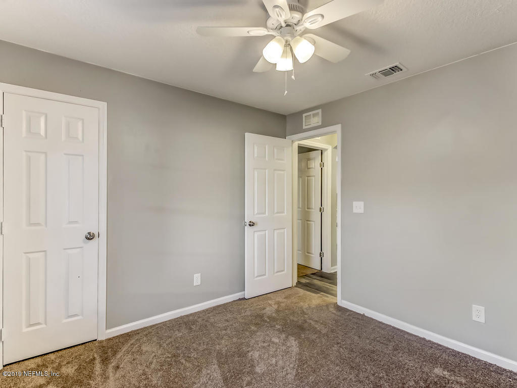 2165 Tuskegee Road Jacksonville, FL 32209 - Photo 23 of 32 an empty room with a chandelier fan