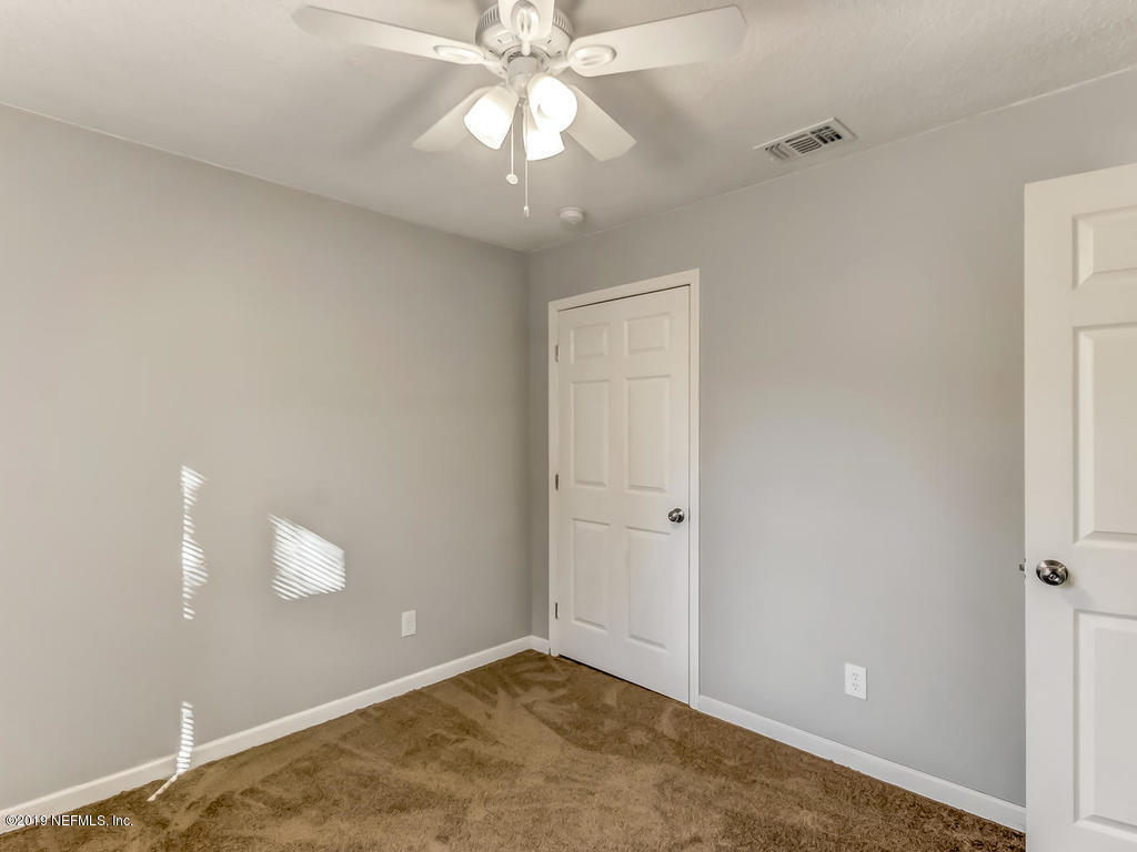 2165 Tuskegee Road Jacksonville, FL 32209 - Photo 28 of 32 an empty room with a chandelier fan and closet area