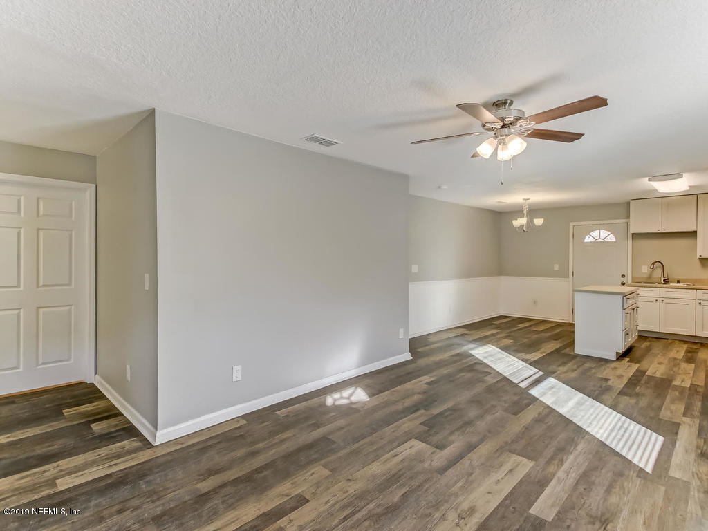 2165 Tuskegee Road Jacksonville, FL 32209 - Photo 6 of 32 a view of a livingroom with a kitchen stove and wooden floor