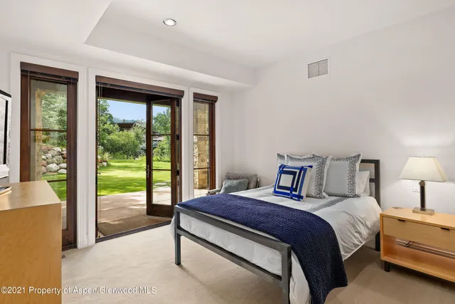 a bedroom with a balcony a large bed and a large window
