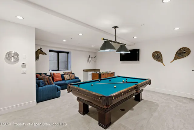 a living room with furniture pool table and window