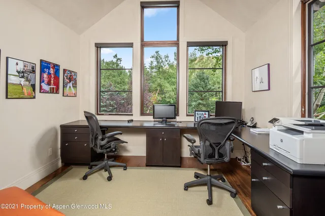 a view of a workspace with furniture and a window