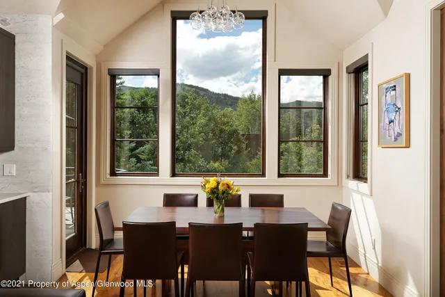 a view of a dining room with furniture large windows and wooden floor