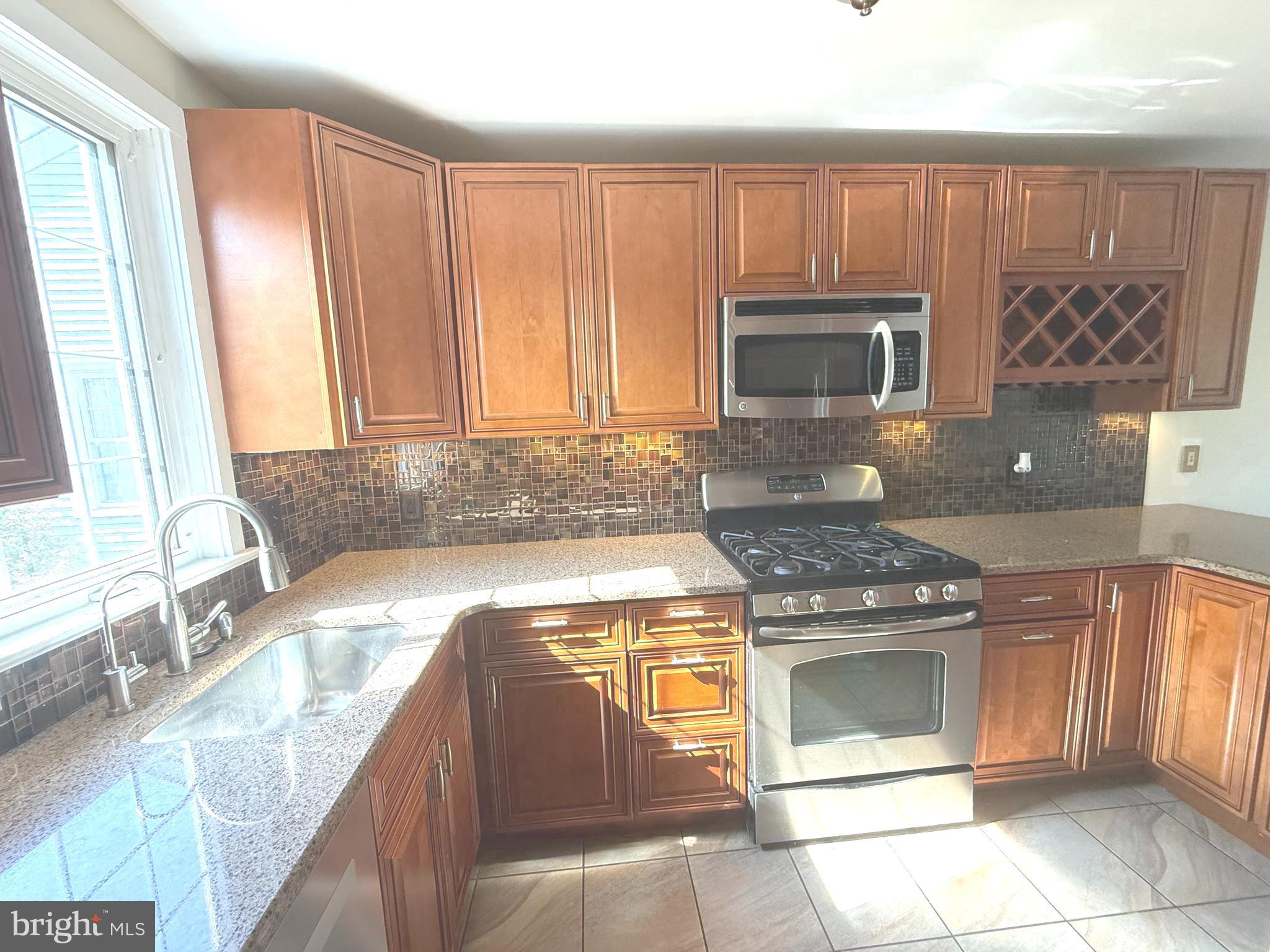 229 Edge Hill Road Glenside, PA 19038 - Photo 3 of 25 a kitchen with granite countertop a stove top oven microwave and cabinets