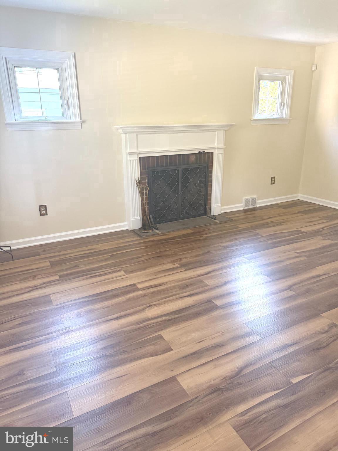 229 Edge Hill Road Glenside, PA 19038 - Photo 8 of 25 an empty room with wooden floor fireplace and windows