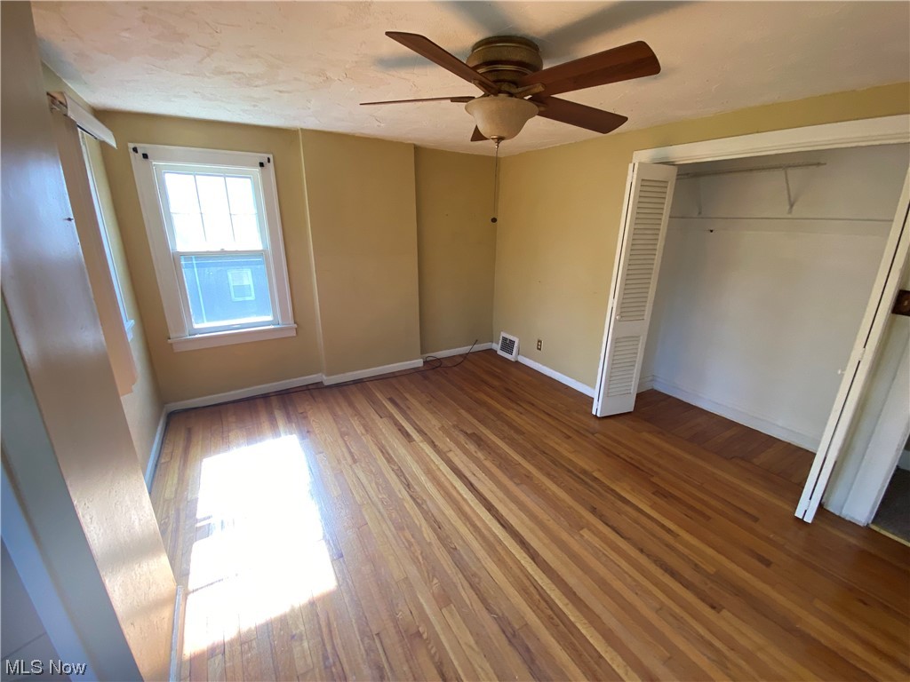 3630 Bainbridge Road Cleveland Heights, OH 44118 - Photo 12 of 21 Unfurnished bedroom featuring hardwood / wood-style flooring, ceiling fan, and a closet