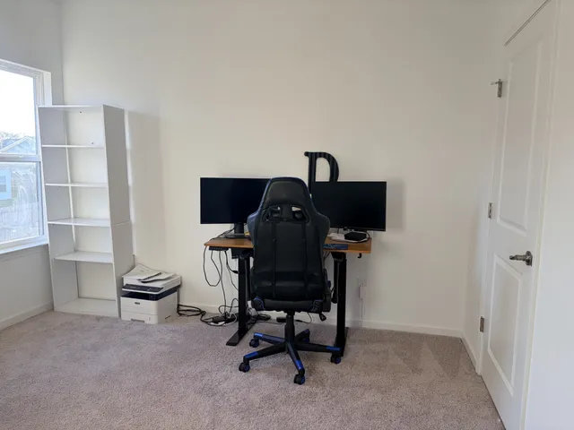 a view of a workspace with furniture and a window