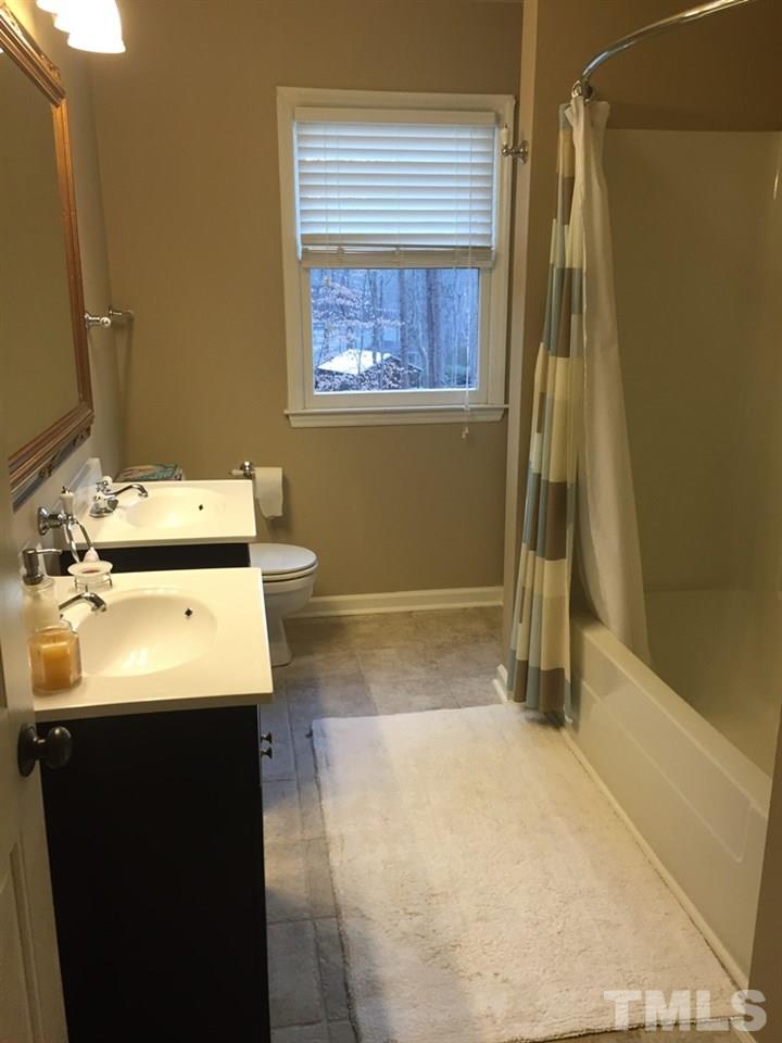 12005 Shooting Club Road Raleigh, NC 27613 - Photo 21 of 25 a bathroom with a sink a toilet and a shower