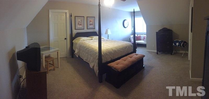 12005 Shooting Club Road Raleigh, NC 27613 - Photo 24 of 25 a bedroom with a bed lamp and a mirror