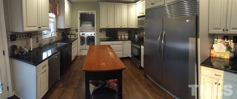 12005 Shooting Club Road Raleigh, NC 27613 - Photo 8 of 25 a kitchen with stainless steel appliances granite countertop a refrigerator a stove and a sink with wooden floor