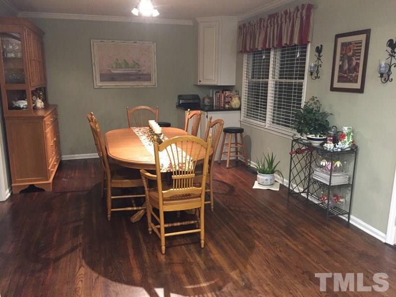 12005 Shooting Club Road Raleigh, NC 27613 - Photo 10 of 25 a dining room with furniture potted plants and wooden floor