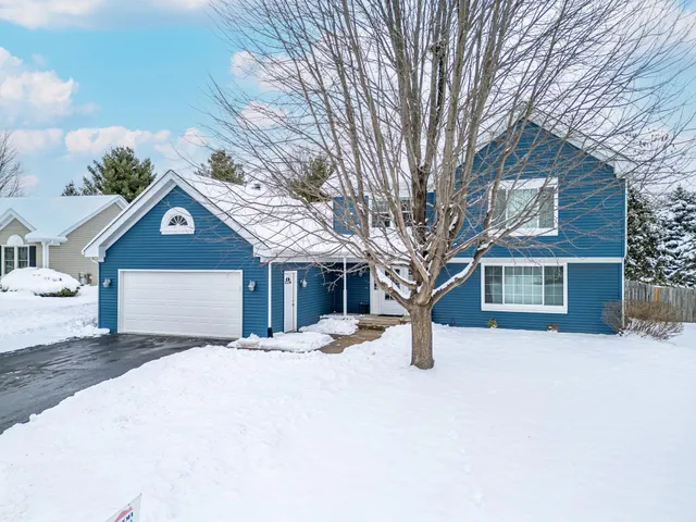 a view of a house with a yard covered in snow