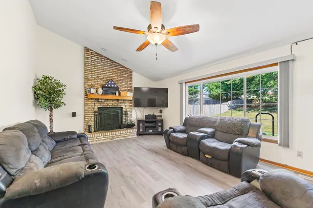 a living room with furniture a fireplace and a chandelier