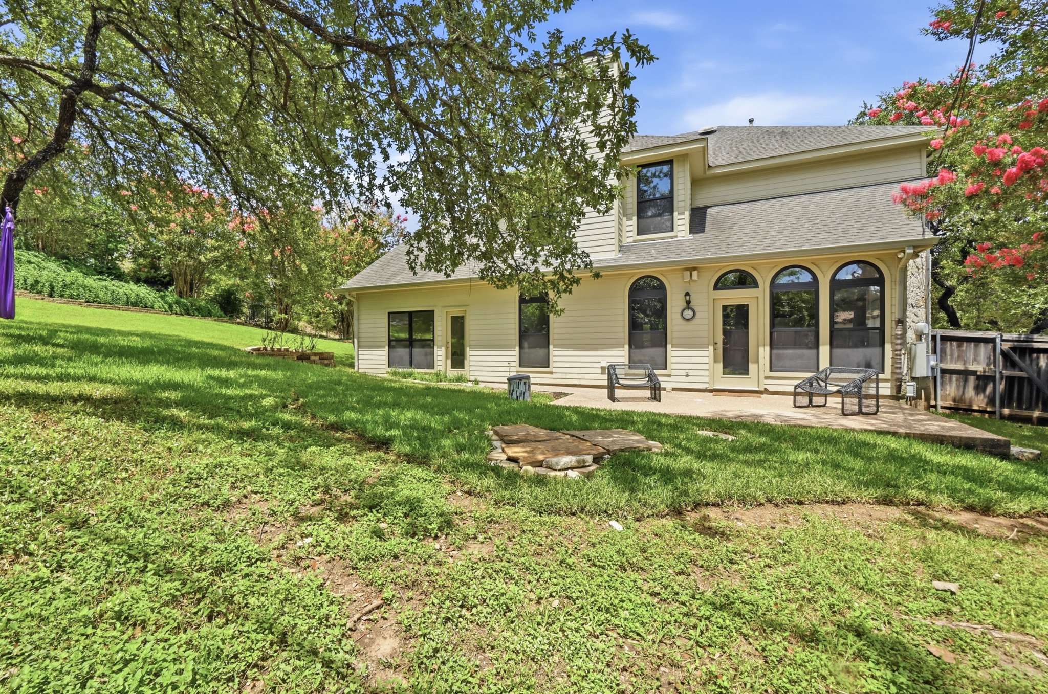 1107 Bowie Road Austin, TX 78733 - Photo 36 of 40 A verdant backyard with mature trees and a spacious patio awaits outdoor enjoyment.