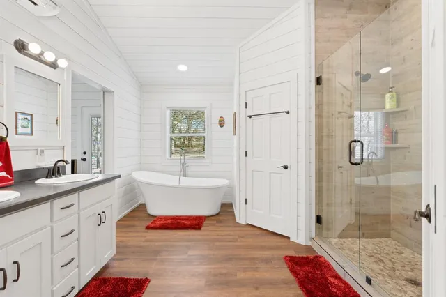 a bathroom with a tub sink shower and mirror