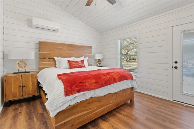 a bed sitting in a bedroom next to a window and a wooden floor