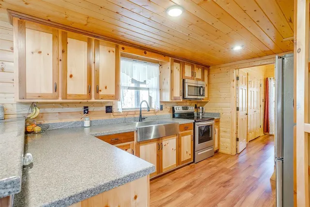 a kitchen with stainless steel appliances granite countertop wooden cabinets a sink and a stove